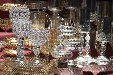 Tezgahında metalik desenler olan cam şarap kadehleri ve kaseler. Yere kırmızı kapak aç..