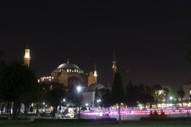 Gece manzaralı ve sokak lambalı Ayasofya Camii. Havuzun kenarından ateş ediyorlar..