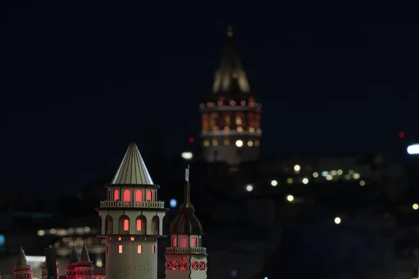 Model of Galata tower and real Galata tower in background.