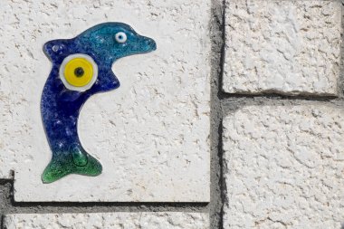 Duvara işlenmiş cam yunus ve üzerine işlenmiş nazar boncuğu..