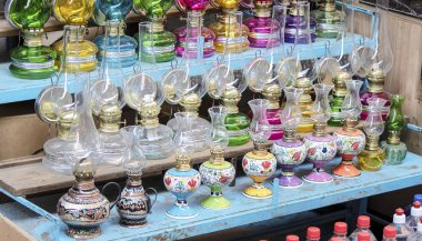 Gaz lambası satan bir tezgahın yakın çekimi. Doğu kültürünün kalıplarıyla boyanmış..