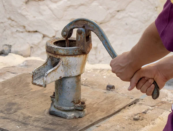Ancienne pompe à eau historique. Appuyer à la main sur la poignée de la pompe — Photo