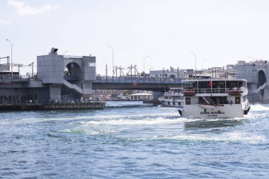 İstanbul, Türkiye - Eylül-28. 2019: Halaklarda yolcu taşıyan gemiler. Arka planda Galata köprüsü.