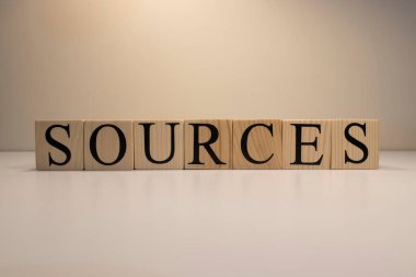 Kaynaklar ahşap küplerden mesaj gönderiyor. Beyaz bir arkaplanda.