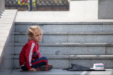 İstanbul, Türkiye - Ekim-Ekim 27.2019: Küçük sarışın kız evsiz ve dilenci. Kötü durumda ve kaldırımda dileniyorsun..