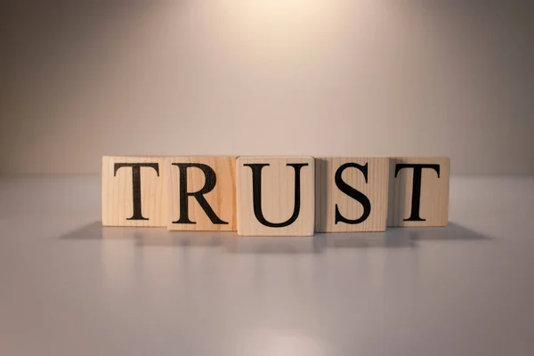 Tahta küplerden güven kelimesi. Leke ışığı ve beyaz arkaplan.