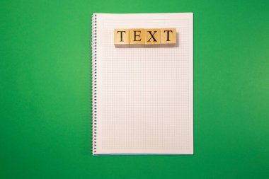 Tahta küplerden yazılar. Not defteri ve yeşil arkaplan altında.