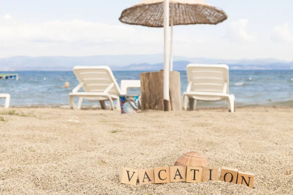 木製のキューブからの休暇の概念 砂や日光の影に埋め込まれた木製のキューブ — ストック写真