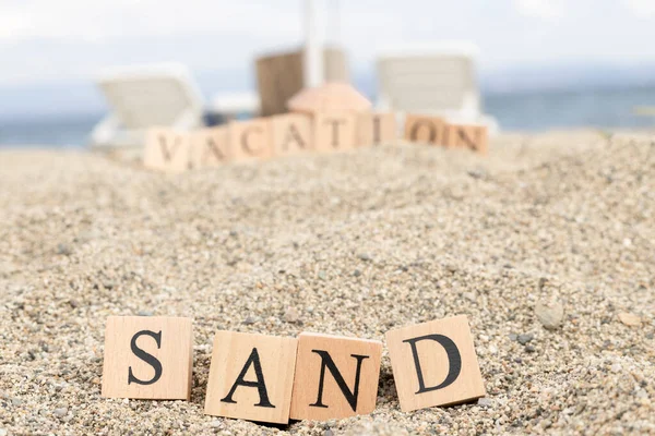 木製の立方体から砂という言葉 ビーチの砂の上でクローズアップ 夏の日に撮影 — ストック写真