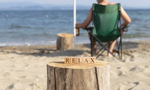 木製のキューブから言葉がリラックス ビーチの砂の上でクローズアップ 夏の日に撮影 — ストック写真