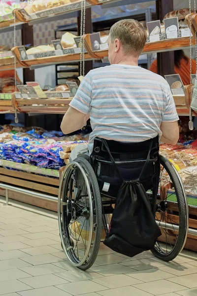 スーパーマーケットの車椅子の買い物客 特別なニーズを持つ人々 ストックフォト