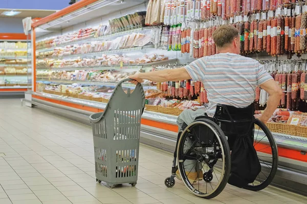 Shopping in sedia a rotelle nel supermercato Foto Stock