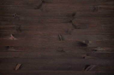 Koyu kahverengi grunge ahşap arka plan. Koyu ceviz renkli çam ağacı, ahşap doku ve düğümleri korunmuş.