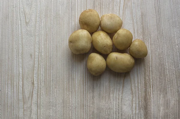 new potatoes, early potatoes, vegetables on a wooden background