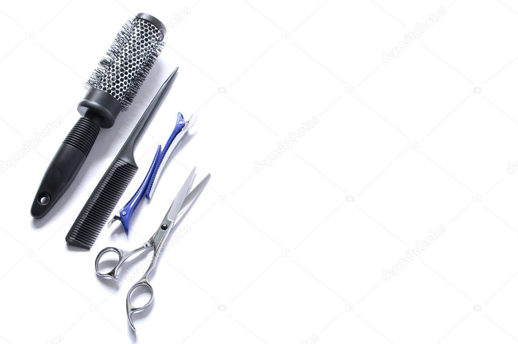 Hairdressing set isolate on white background. Round brush for drying hair, comb with a thin long handle, blue clips for hair, hairdresser's scissors. Barber tools.
