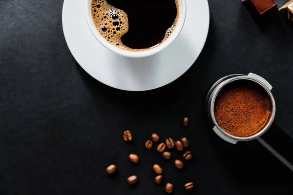 Вкусный кофе на черном столе с шоколадом . — стоковое фото