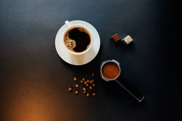 Lekkere koffie op de zwarte tafel met chocolade. — Stockfoto