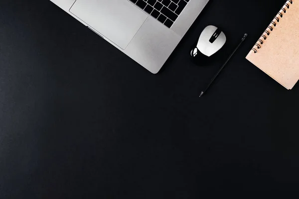 Laptop, computermuis en Kladblok op een zwarte achtergrond. — Stockfoto
