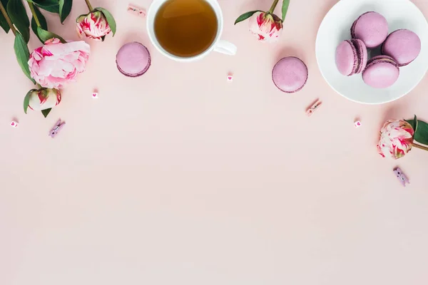 Bir fincan çay ve şakayık ile macaroons üst görünümü.