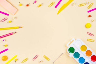 Sarı arka planda okul aksesuarları. Pastel renkli.