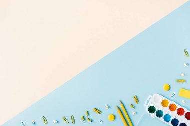 Sarı mavi arka planda okul aksesuarları. Pastel renkli.