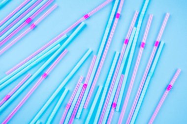 Renkli arka planda mavi ve pembe kokteyl pipetleri.