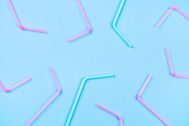 Renkli arka planda mavi ve pembe kokteyl pipetleri.