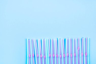 Renkli arka planda mavi ve pembe kokteyl pipetleri.