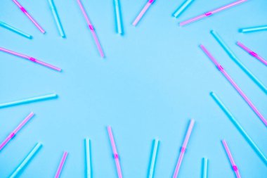 Renkli arka planda mavi ve pembe kokteyl pipetleri.