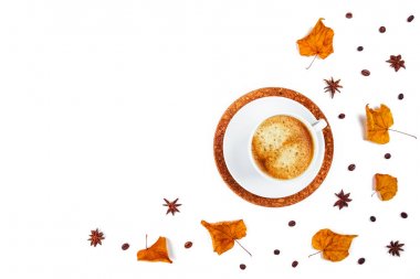 Beyaz Fincan kahve yaprakları ve yıldız anason çevrili.