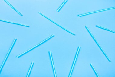 Renkli arka planda mavi kokteyl pipetleri.