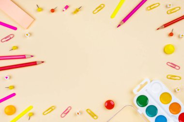 Sarı arka planda okul aksesuarları. Pastel renkli.
