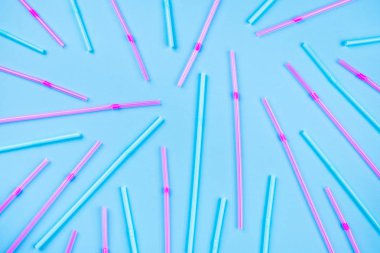 Renkli arka planda mavi ve pembe kokteyl pipetleri.