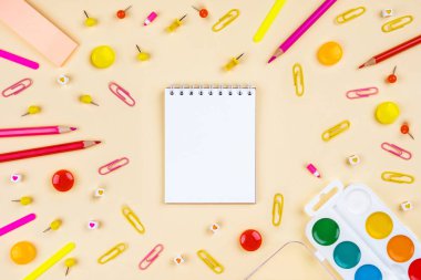 Sarı arka planda okul aksesuarları. Pastel renkli.
