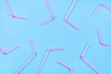 Renkli arka planda pembe kokteyl pipetleri.