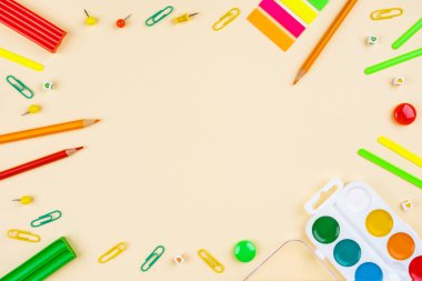 Sarı arka planda okul aksesuarları. Pastel renkli.