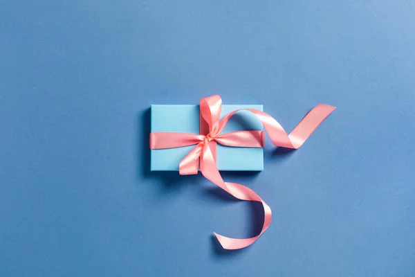 Biglietto natalizio. Una scatola blu con un fiocco rosa. — Foto Stock