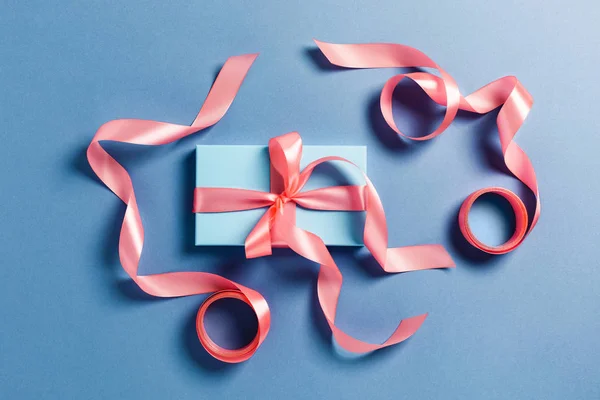 Biglietto natalizio. Una scatola blu con fiocchi rosa . — Foto Stock