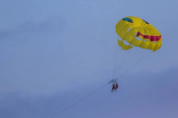 Yellow parachute. Blue sky background.