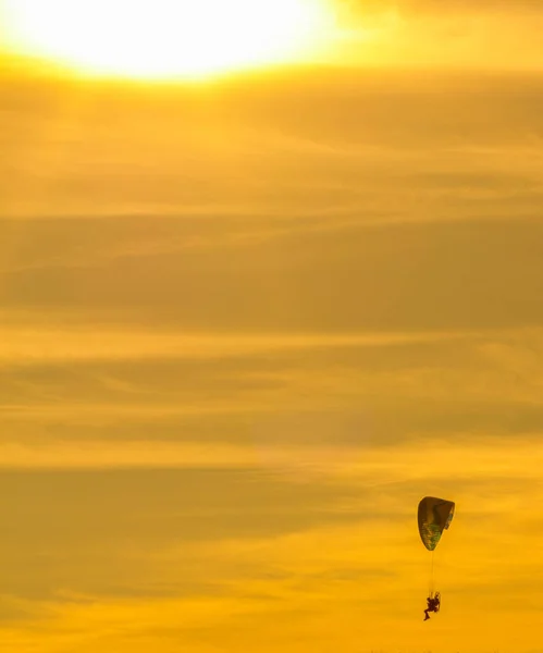 Sunset with paragliders pilot flying over clouds — Stock Photo, Image