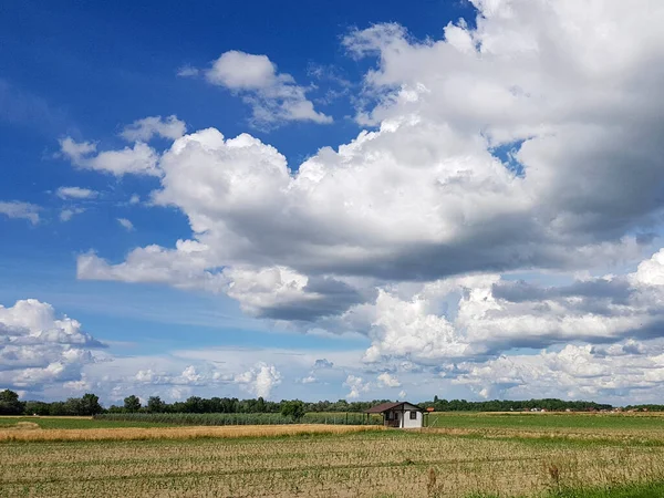Büyük beyaz bulutların ve küçük evin güzel bir görüntüsü. alan önde.