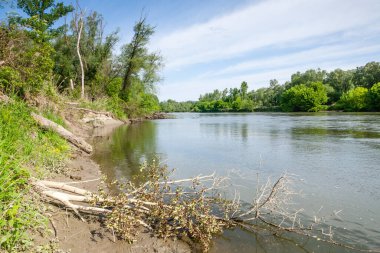 Mavi bir arkaplanda yeşil bir manzarada yansıtıcı bir gölün güzel bir görüntüsü.