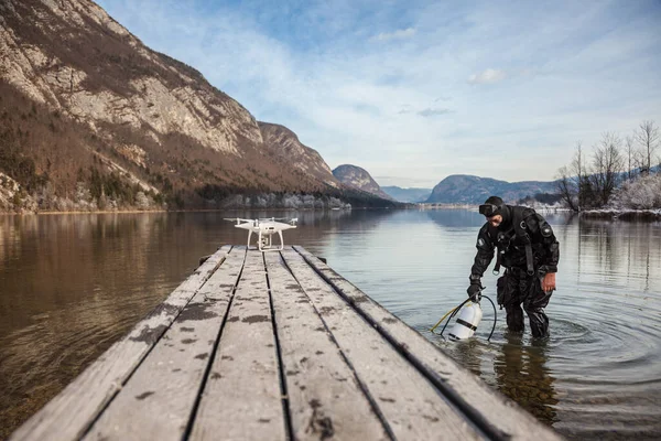 Drone Crash - Dalgıç Kurtarılmış bir İHA 'nın yanında duruyor