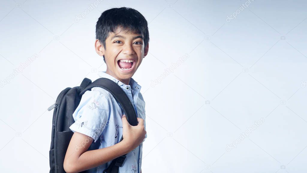 School boy with backpack in shock expression isolated on white.