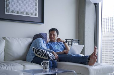 Evde kanepede oturan genç bir sevmek çift