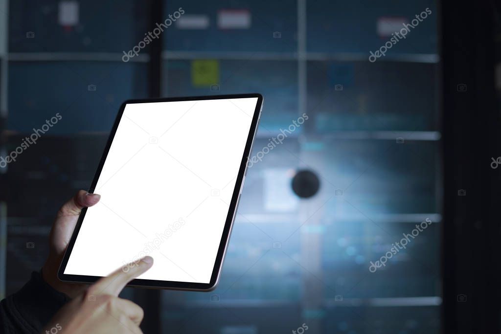 Businessman finger touching screen of a digital tablet againts blurred background