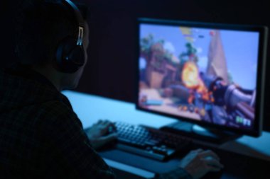 karanlık bir odada video oyunları oynayan genç adam