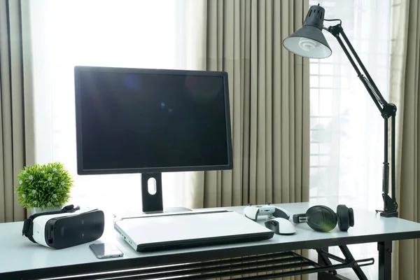 All in one computer, mouse, keyboard, laptop, smartphone, vr glasses, game console, and headphone on white table work desk