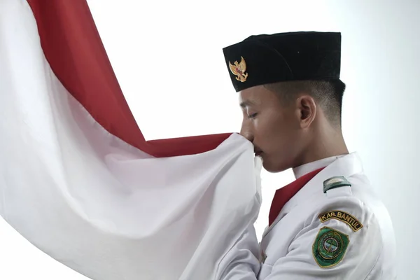 Zbliżenie Młody Człowiek Indonezyjskie Flaga Narodowa Podnoszenie Troop Całując Flagę — Zdjęcie stockowe