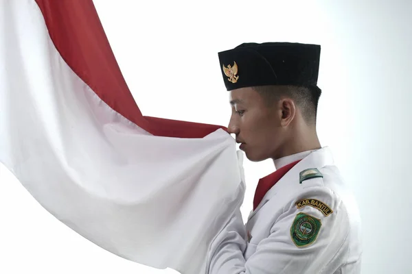 Zbliżenie Młody Człowiek Indonezyjskie Flaga Narodowa Podnoszenie Troop Całując Flagę — Zdjęcie stockowe